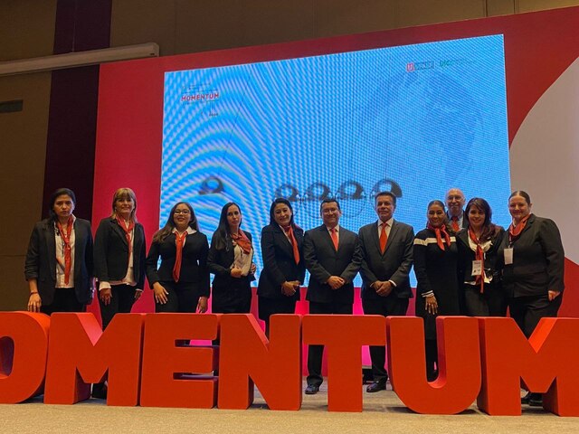 Equipo de maestros posando para una fotografia en una conferencia